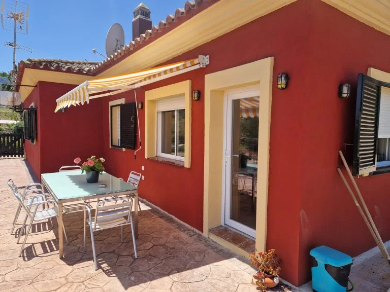 Rode gevel en terras van het appartement bij Rancho Pancho
